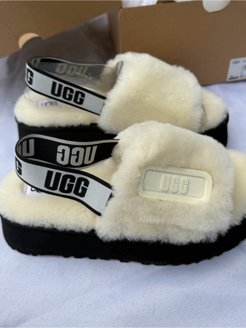 UGG Cream Sheepskin Fluff Slide with Black-and-White Branded Strap. Disco Slide